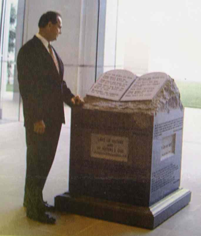 The honorable Judge Roy Moore standing by God's Ten Commandments.