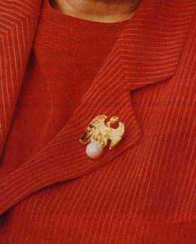    Enlargement of Phoenix pin on red corduroy suit coat worn by Hillary Rodham Clinton.   
