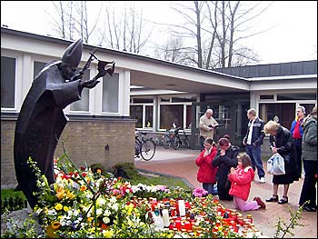 Blinded Catholics worshipping a statue of Pope John Paul II